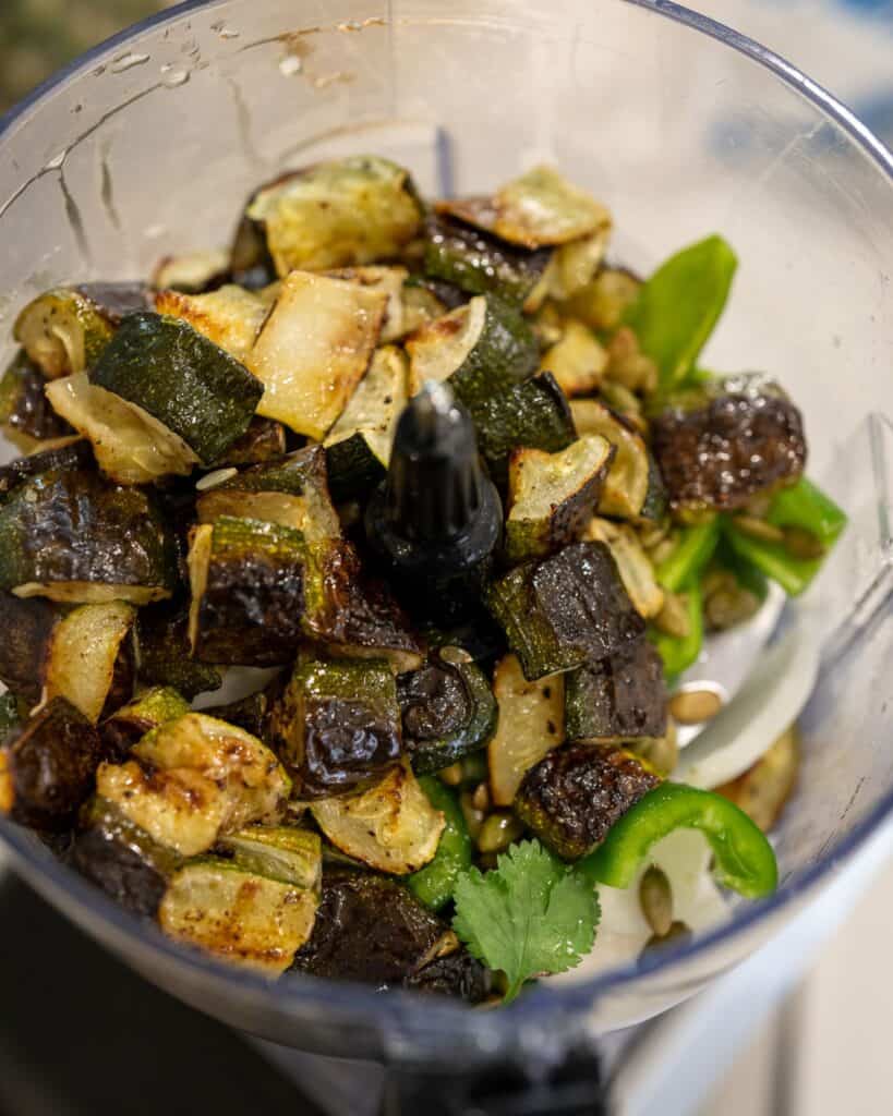 roasted zucchini in a food processor with fresh salsa ingredients