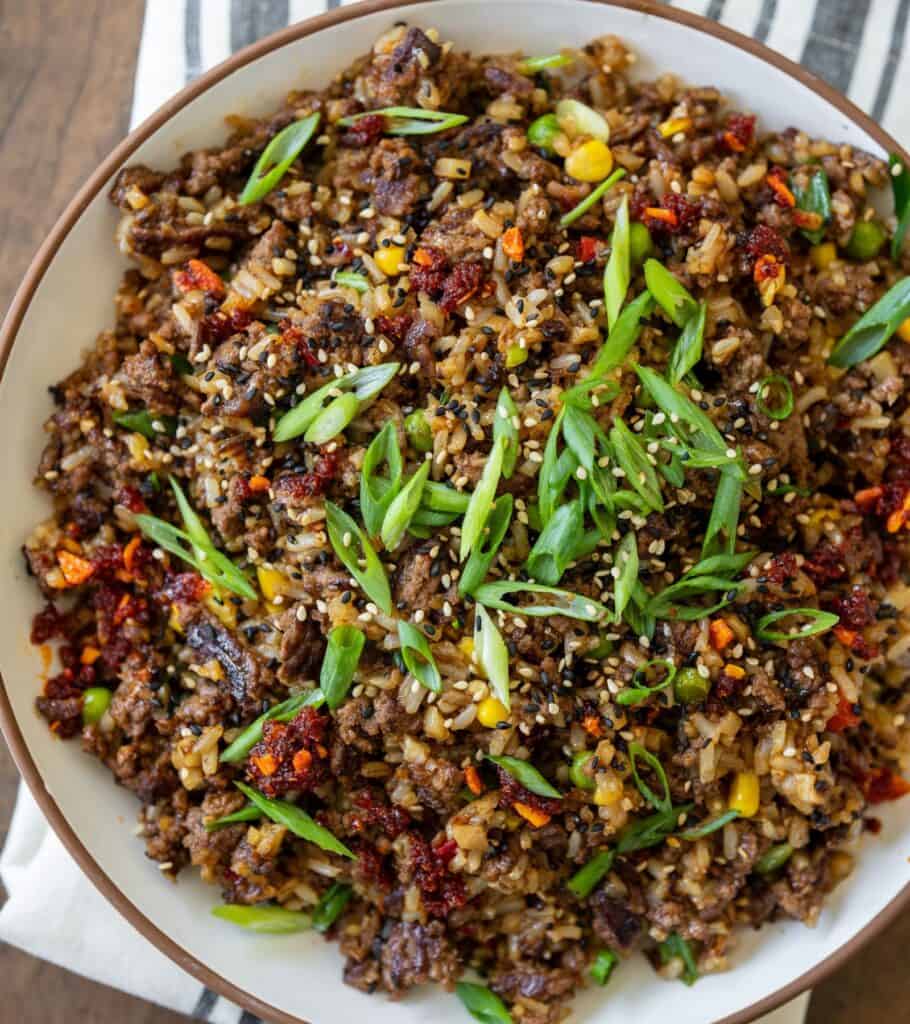 ground beef fried rice bowls garnished with chili crisp and scallions