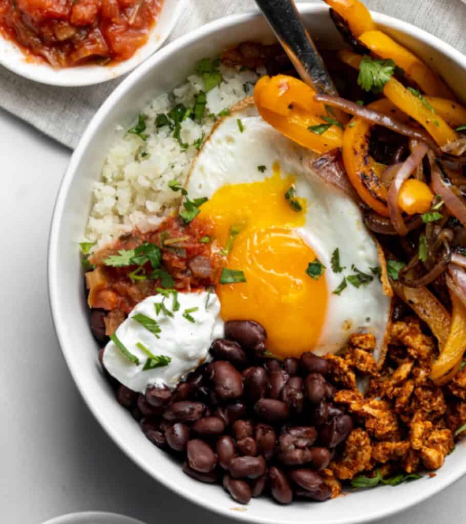 eggs, black beans, peppers, sour cream, and salsa in a bowl