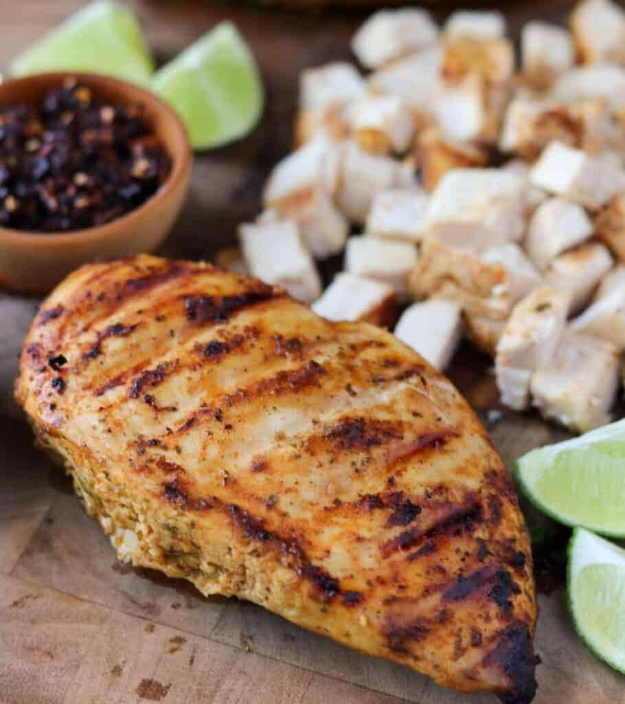 whole grilled chicken breast beside chopped chicken