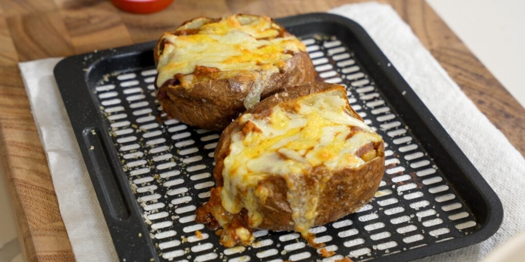 two turkey chili stuffed baked potatoes on an air fryer rack