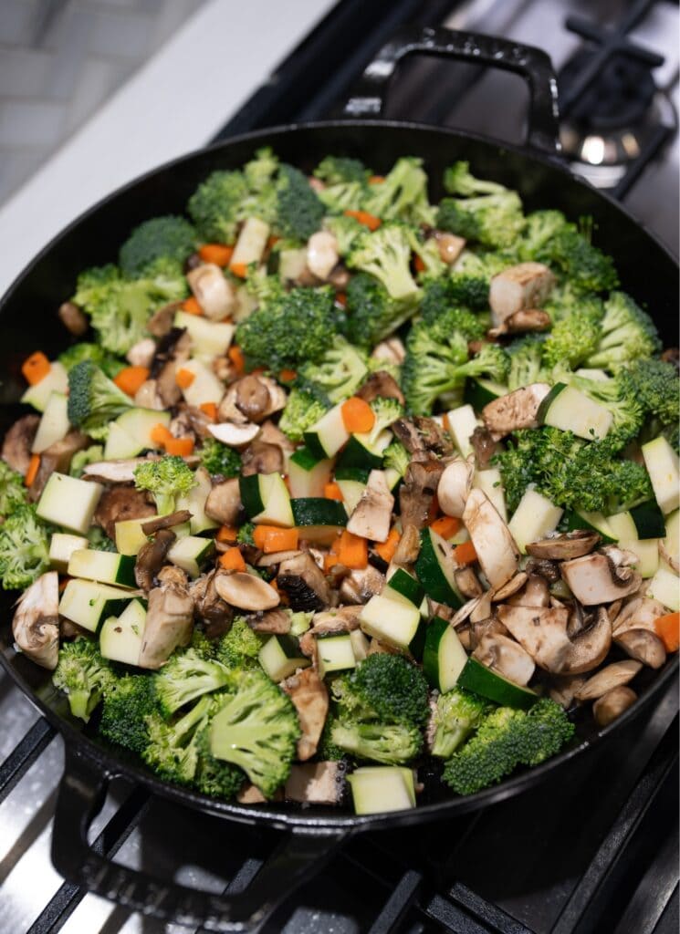 broccoli, carrots, zucchini, and mushrooms in a pan