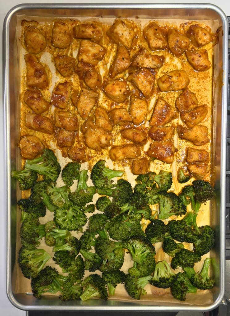 baked Korean chicken bites and broccoli on a half sheet pan