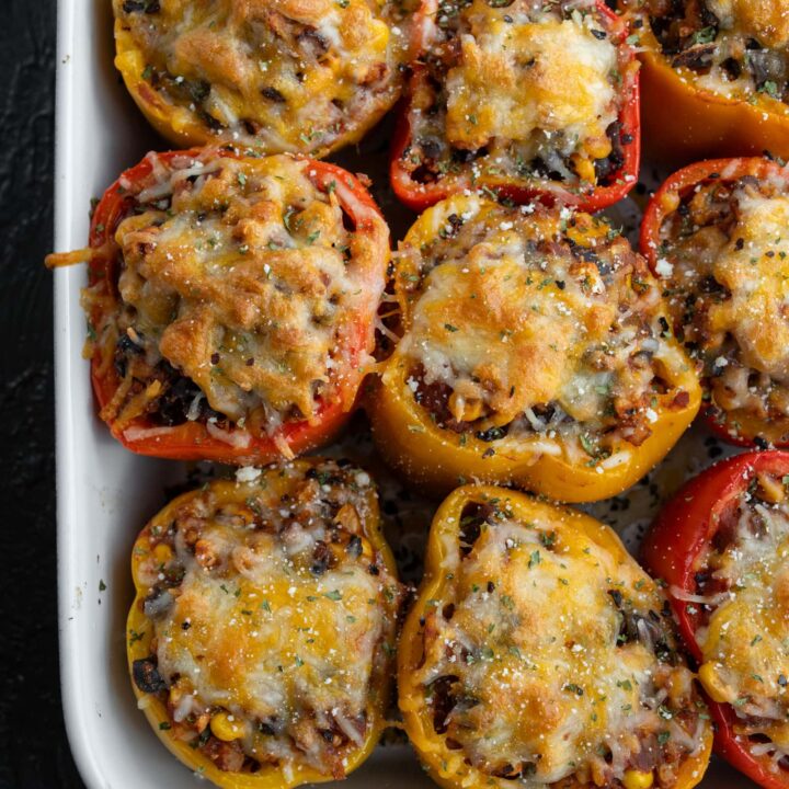 Mexican ground chicken stuffed peppers in a ceramic baking dish