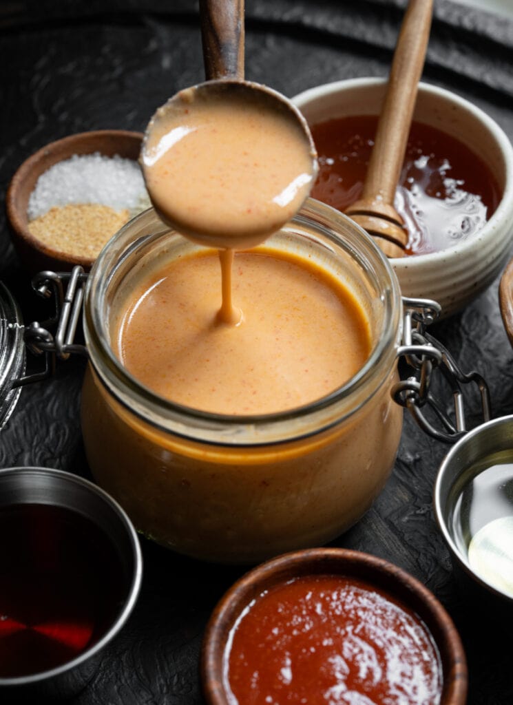 healthy yum yum sauce in a jar with a wooden serving spoon