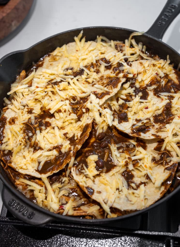 freshly grated pepper jack cheese on top of mole chicken enchilada casserole