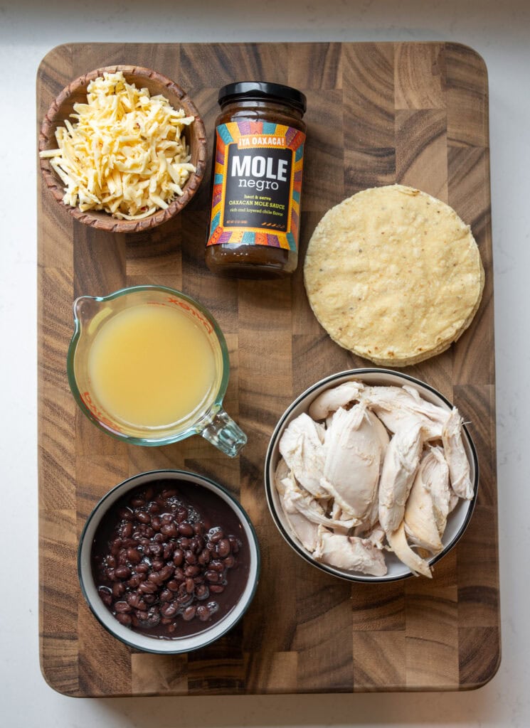 pulled rotisserie chicken, black beans, mole sauce, corn tortillas, chicken bone broth, and grated pepper jack cheese