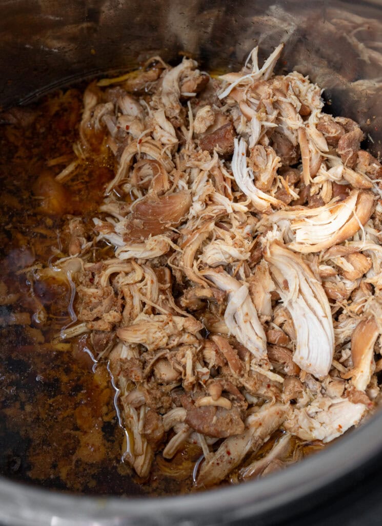shredded chicken in a slow cooker with sauce
