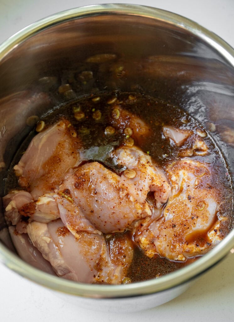 boneless skinless chicken thighs in a slow cooker pot with a Korean BBQ sauce
