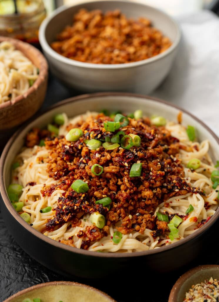 ground chicken and noodle bowls with chili crunch, scallions, and toasted sesame seeds