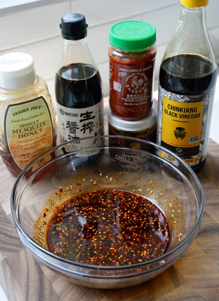 honey, chili crisp, soy sauce, chili garlic sauce, and black vinegar in a glass mixing bowl