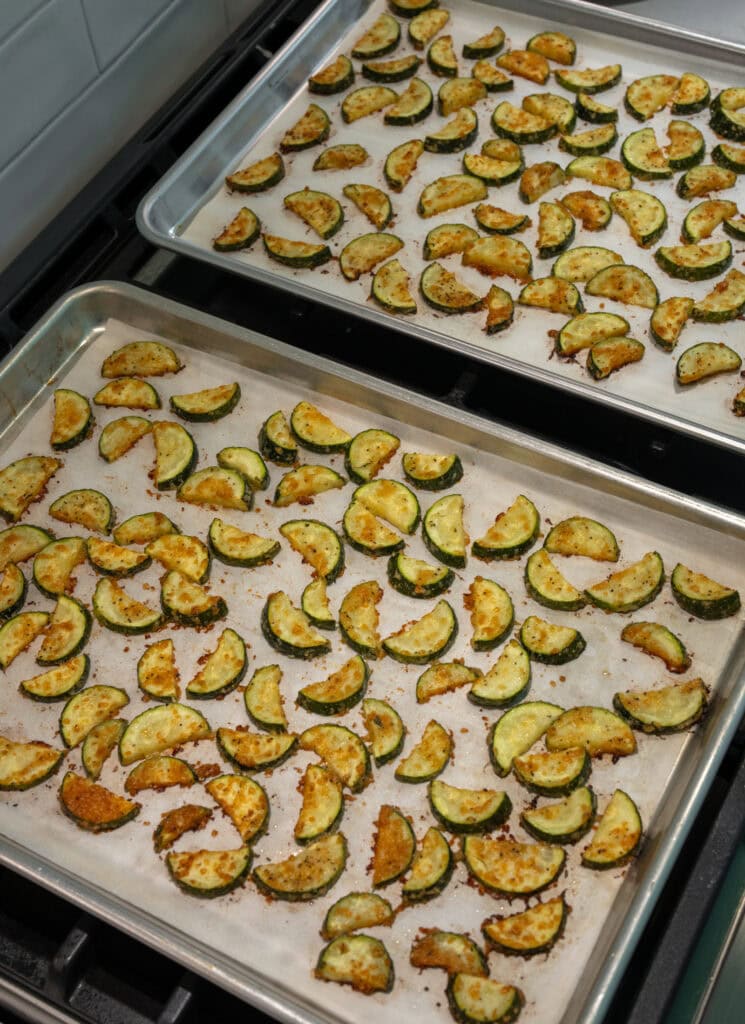 two half sheet pans with roasted zucchini squash