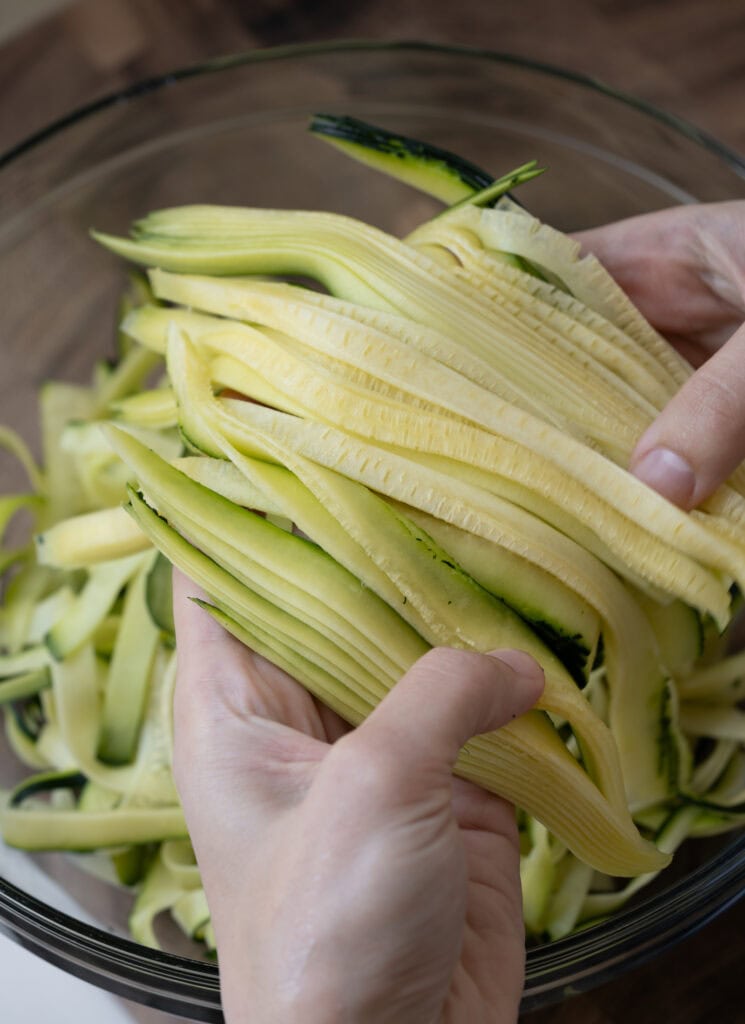 holding hand cut zucchini noodles