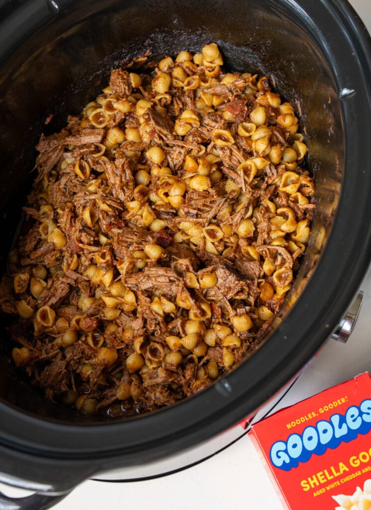 shredded beef and cooked pasta shells in a Crockpot