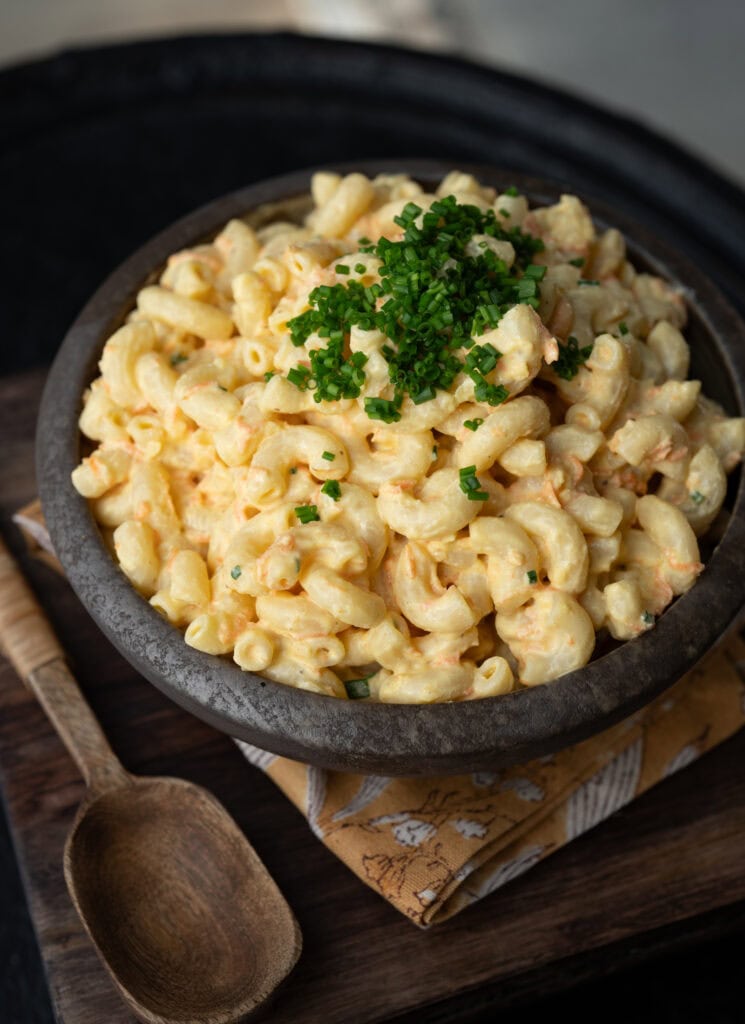 a bowl of high protein macaroni salad garnished with chives