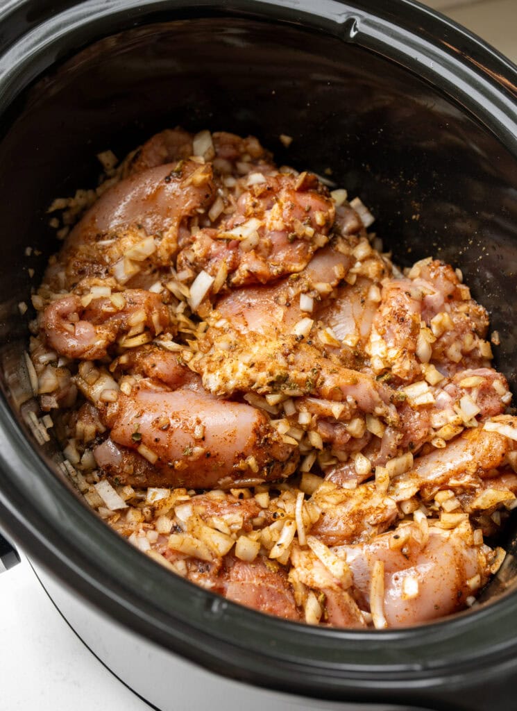 Mexican seasoned chicken thighs in a Crockpot before cooking