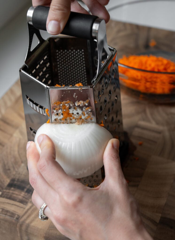 grating a white onion and carrots