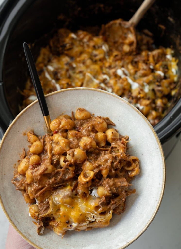 holding a bowl of beef chili mac over a Crockpot