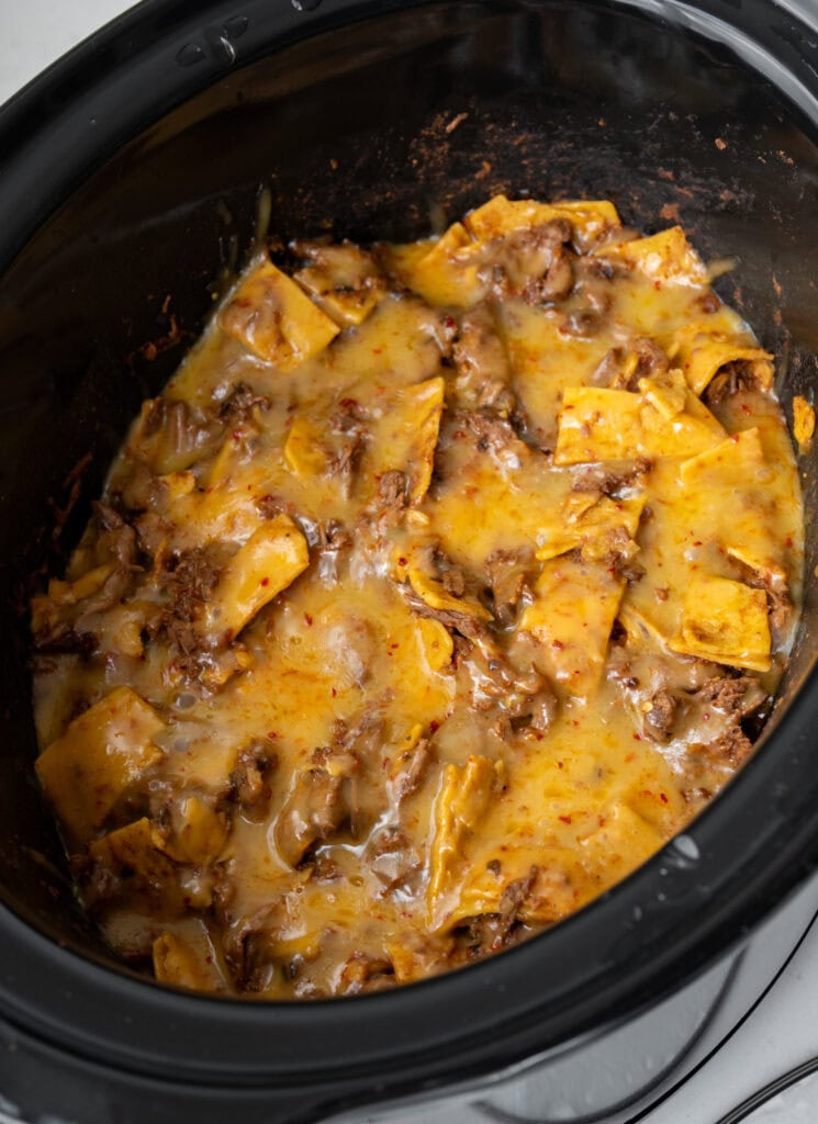 melted cheese on a finished beef enchilada casserole in a Crockpot before adding garnishes