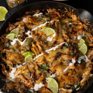cast iron skillet casserole with tortilla chips and garnishes