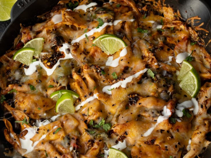 cast iron skillet casserole with tortilla chips and garnishes