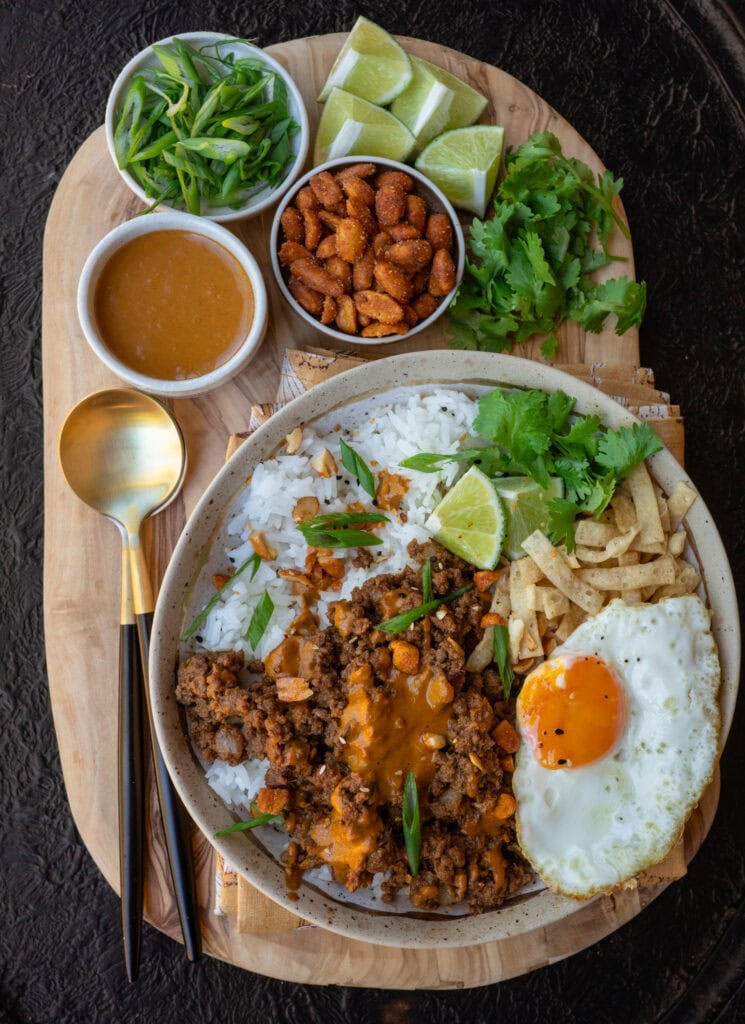 Thai curried ground beef and rice bowl with peanut sauce and garnishes