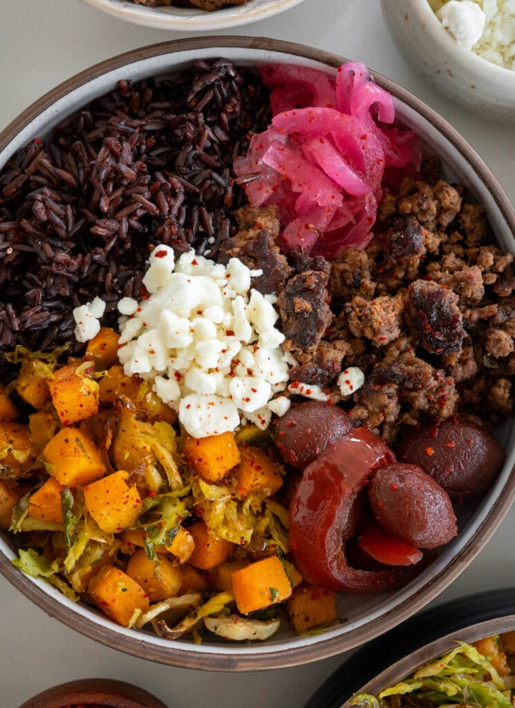 ground beef and butternut squash bowls with pickled onions, pickled beets, forbidden rice, and goat cheese