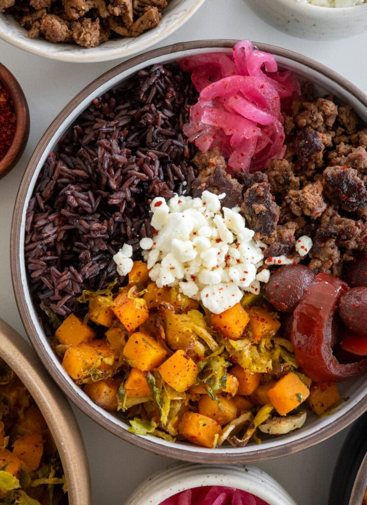 ground beef bowls with roasted butternut squash and shaved brussels sprouts, forbidden rice, goat cheese, pickled beets and onions