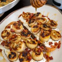 drizzling honey over cottage cheese toast with bananas and peanut butter
