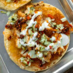 cheese crust tortilla topped with crispy baked chicken breast, pickle de gallo, ranch, chili crisp, and a honey drizzle