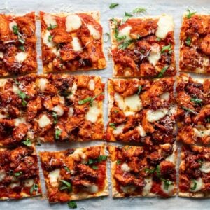 sliced chicken flatbreads garnished with basil and shaved parmesan