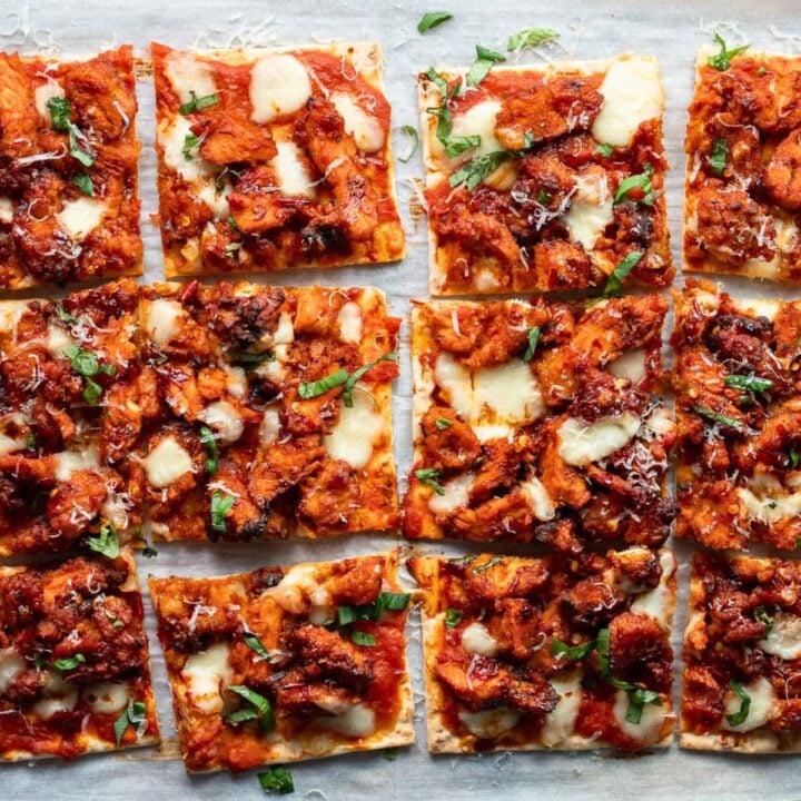 sliced chicken flatbreads garnished with basil and shaved parmesan