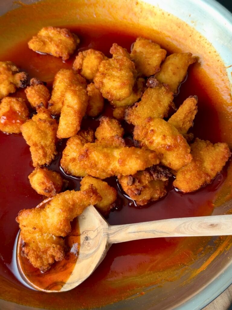 air fried chicken bites in a stainless steel skillet with honey chipotle sauce