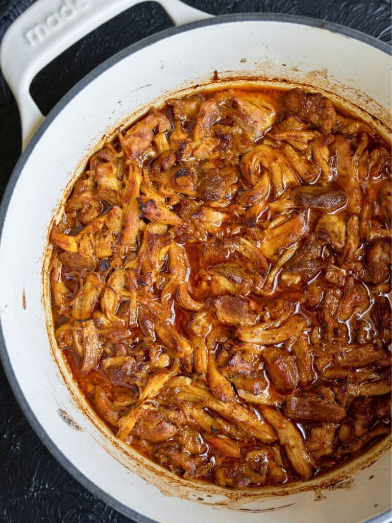 baked and broiled shredded chicken in a Dutch oven