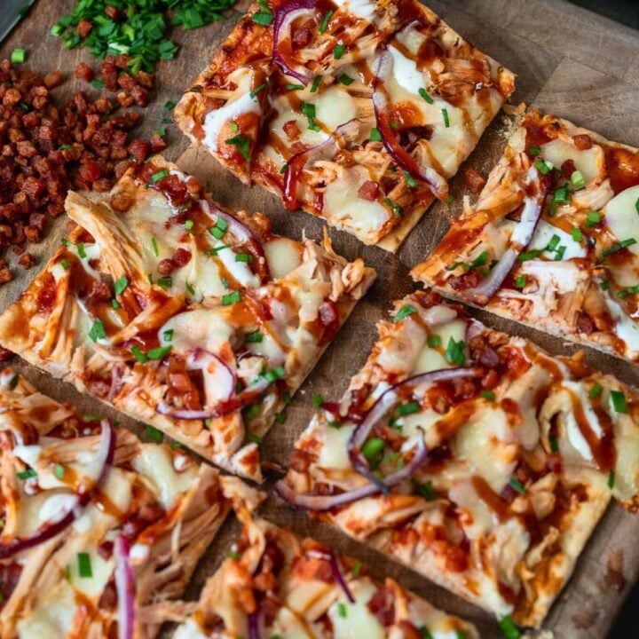 picking up a piece of rotisserie chicken flatbread off a cutting board