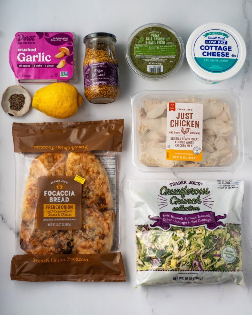 Trader Joe's focaccia, cooked chicken, cruciferous crunch, dijon mustard, low fat cottage cheese, cashew pesto, lemon, black pepper, and frozen crushed garlic