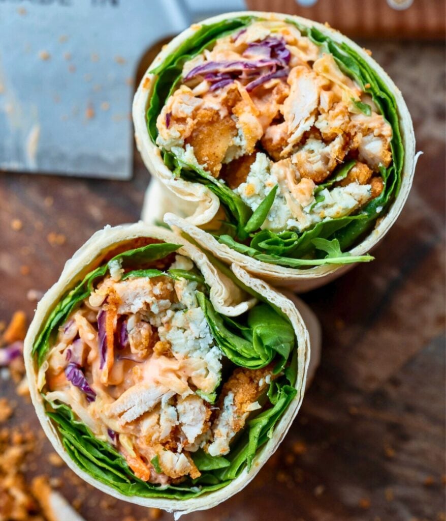 buffalo ranch chicken nuggets wrap sliced in half on a cutting board