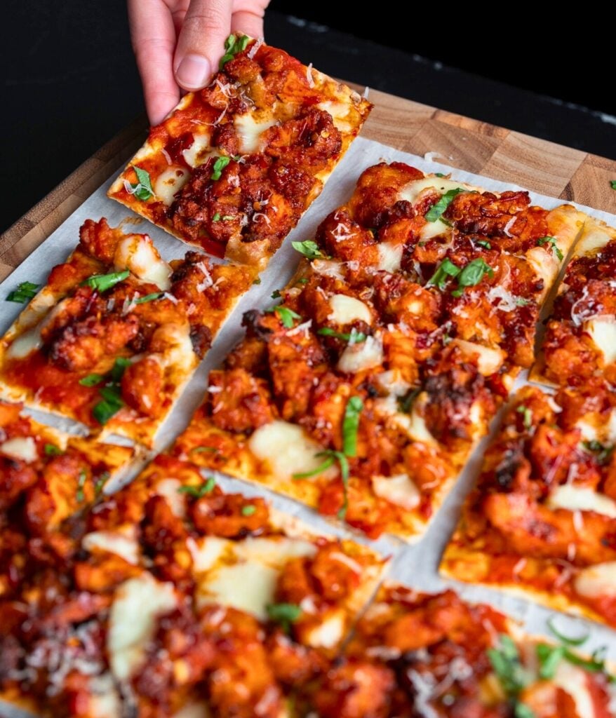 picking up a slice of chicken flatbread pizza