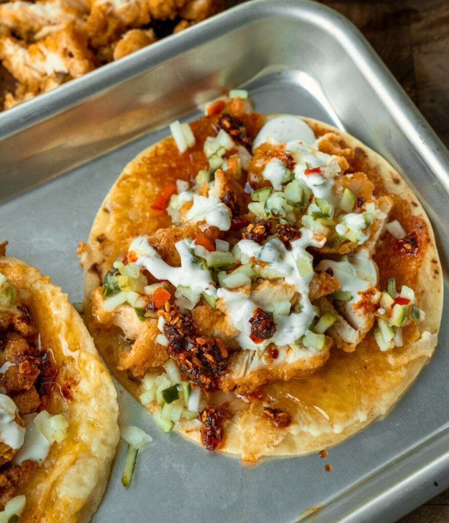 cheese crusted tortilla topped with chopped chicken nuggets, pickle de gallo, and ranch