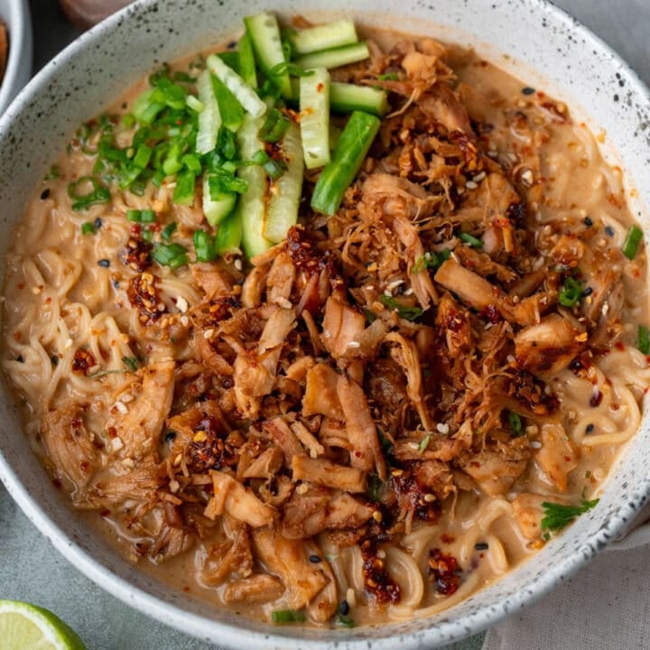 ramen noodles bowl with crispy rotisserie chicken, sliced cucumbers, scallions, and chili crisp