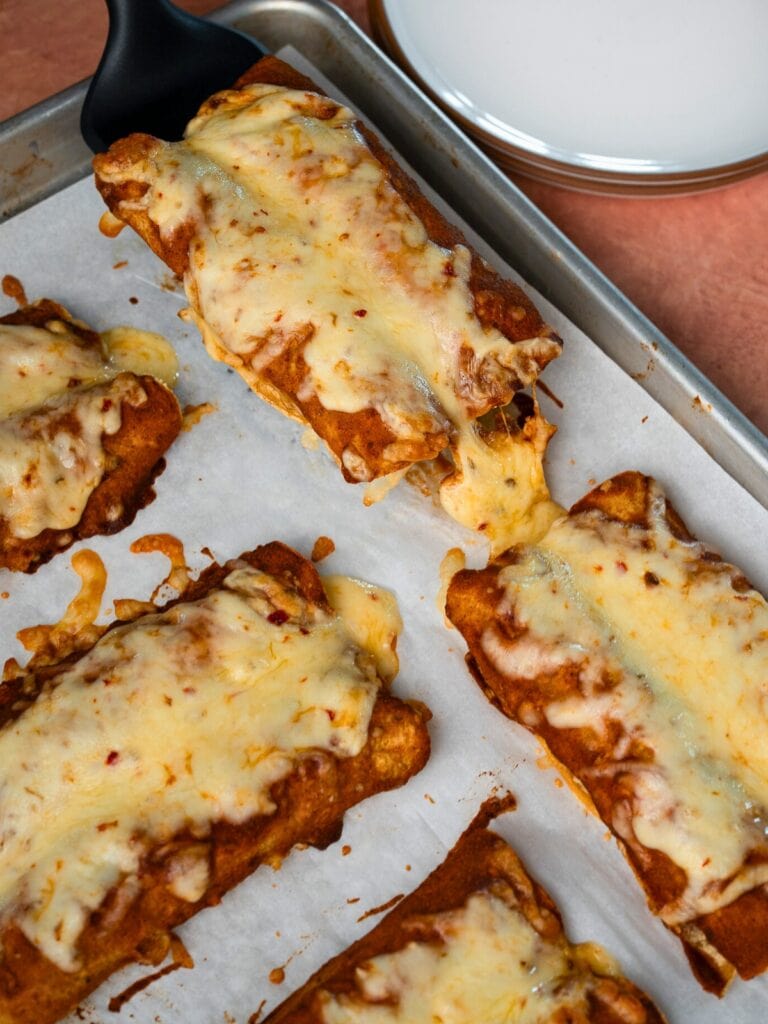 serving a pair of beefy cottage cheese enchiladas off a sheet pan