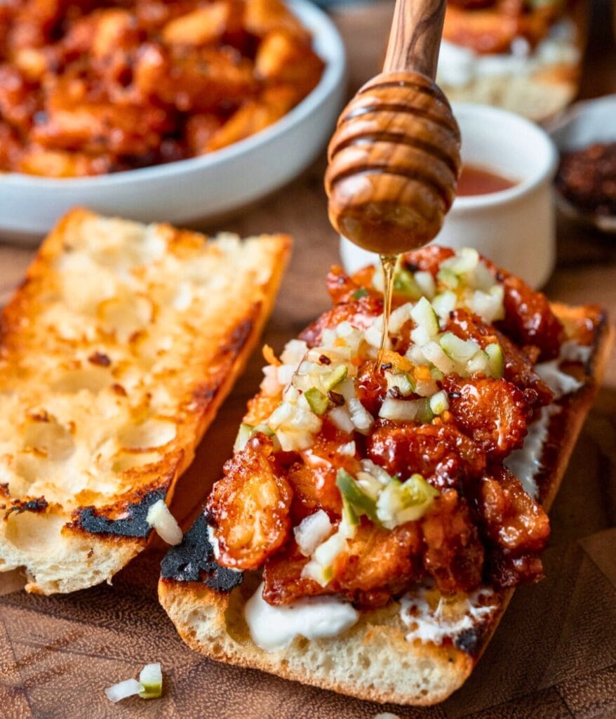 drizzling honey over a honey chipotle chicken sandwich