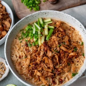ramen bowl with rotisserie chicken, sliced cucumber, scallions, and chili crisp