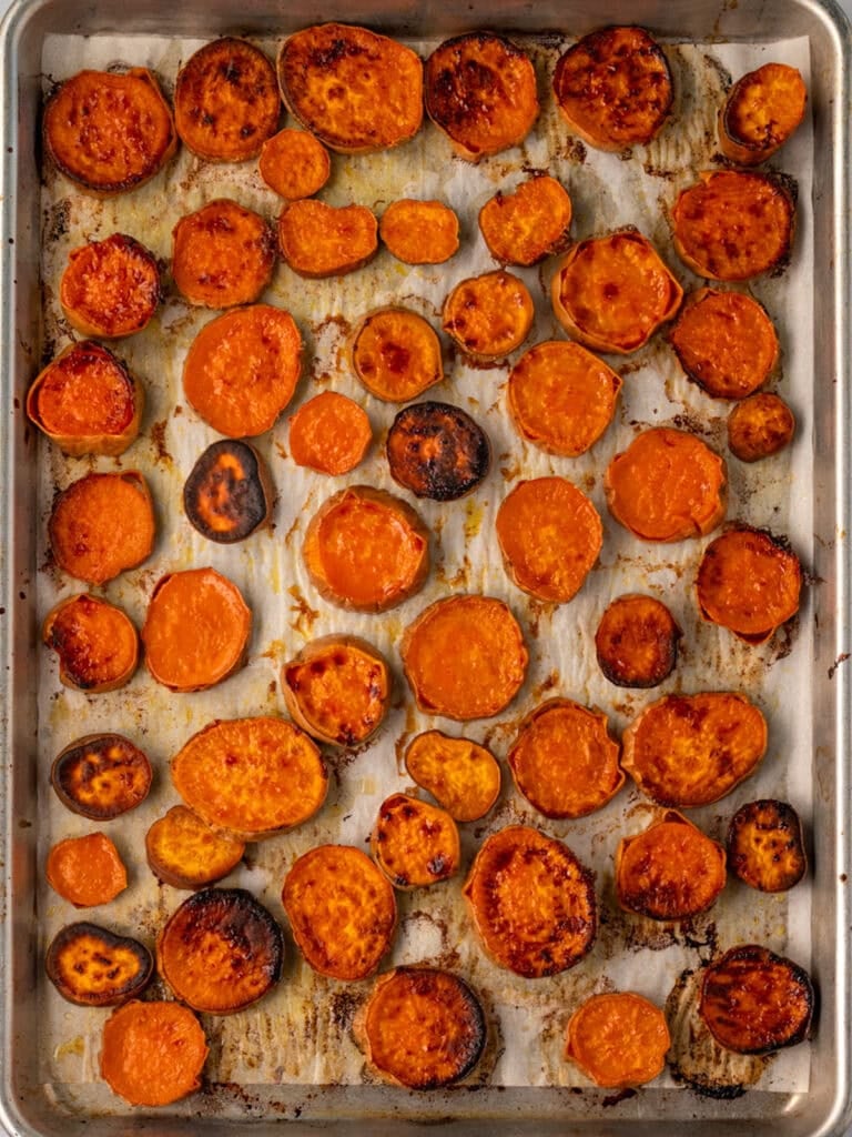 roasted sweet potato rounds on a parchment lined half sheet pan