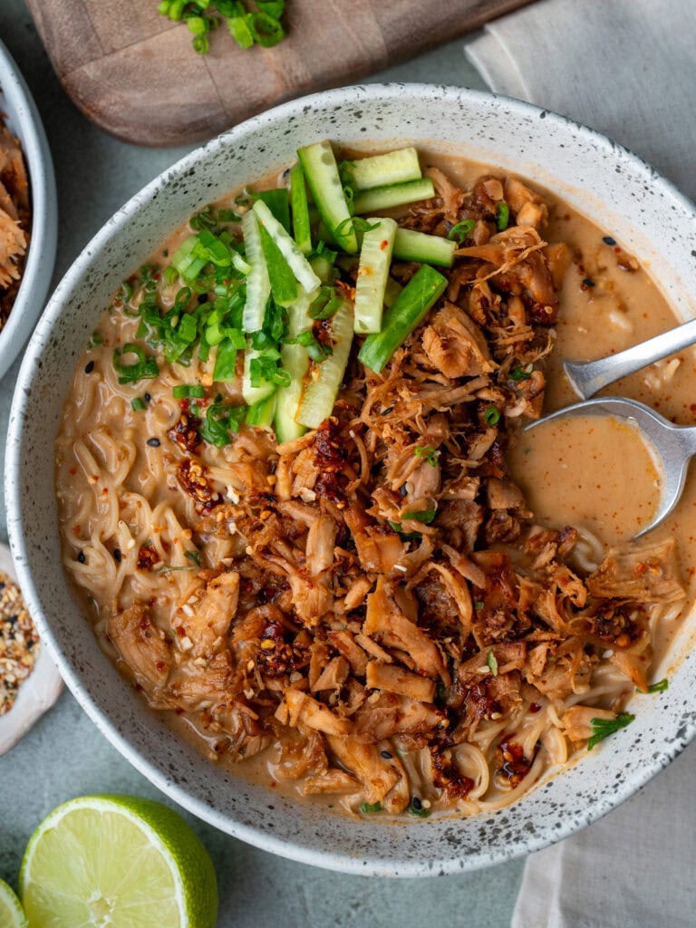spoon and fork inside a bowl of chicken ramen
