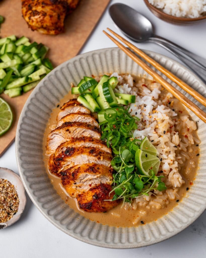brothy rice bowl with sliced chicken breast and garnishes