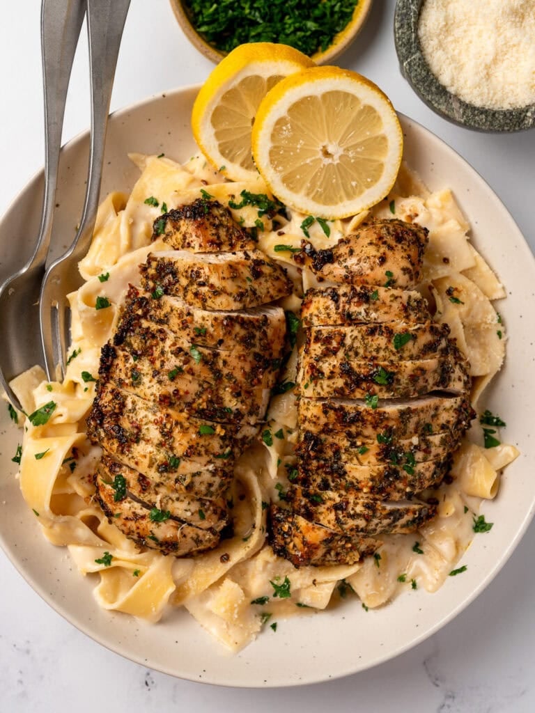 large bowl with chicken alfredo and sliced lemon