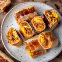 sliced sausage egg and cheese breakfast roll-ups on a plate