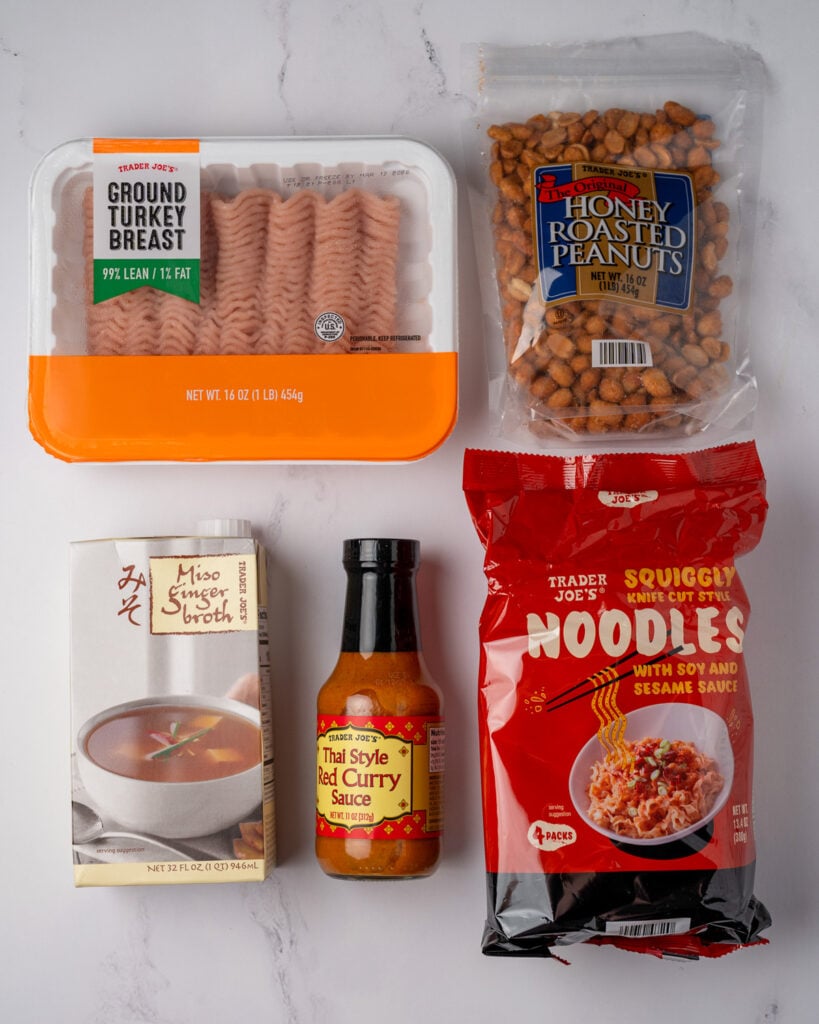 Trader Joe's Thai red curry sauce, miso ginger broth, ground turkey, squiggly knife cut style noodles, and honey roasted peanuts