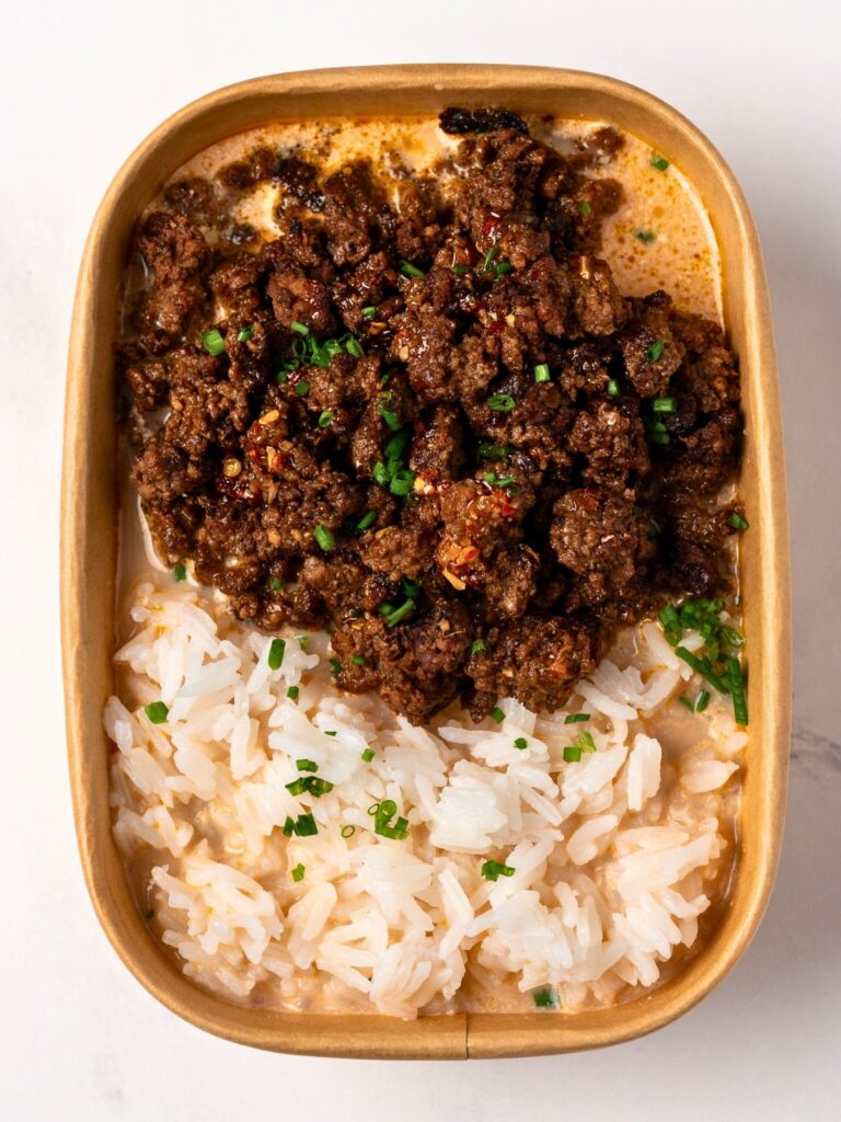 crispy hoisin ground beef, steamed jasmine rice, and miso ginger coconut broth in a meal prep container